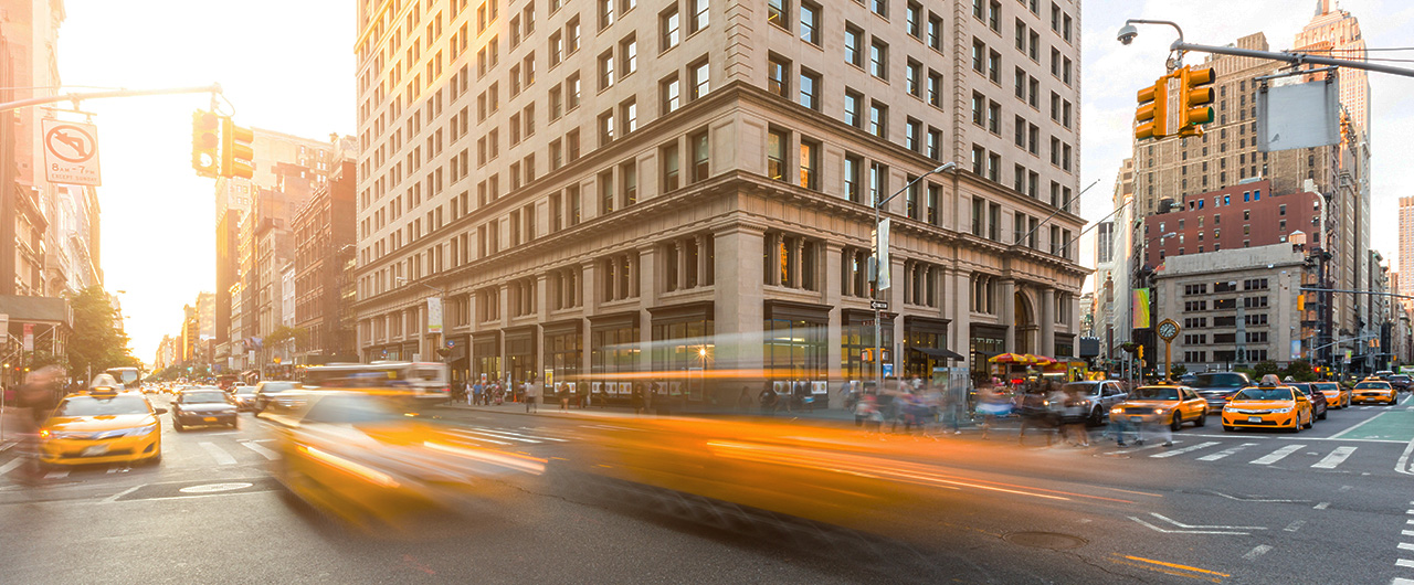 Busy road intersection in Manhattan, New York, at sunset